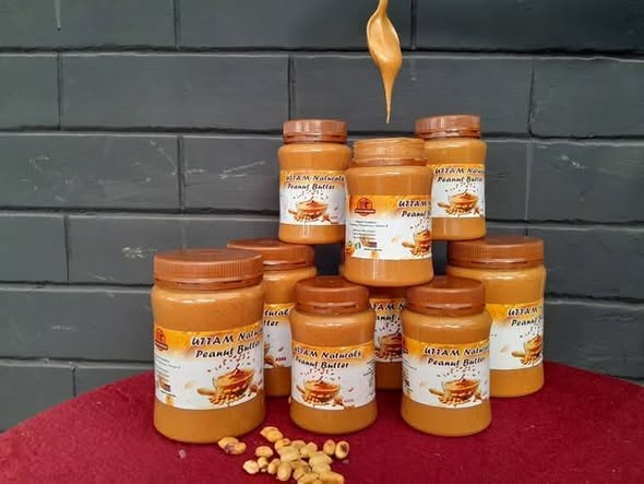 Stacked jars of Uttam Naturals peanut butter